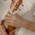 person playing brown wooden guitar